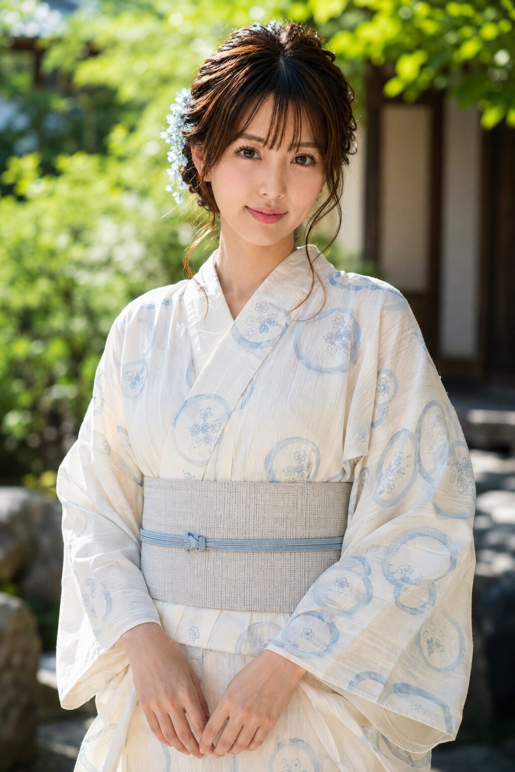 Woman wearing a cream summer yukata with pale blue yukiwa pattern in a garden